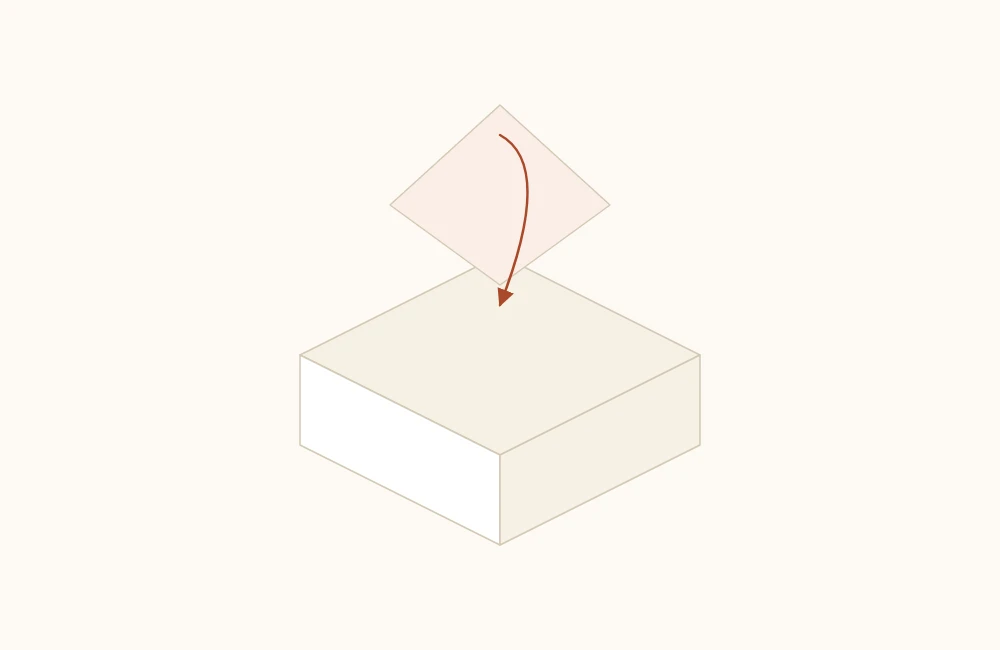 Corner of an origami box being folded inward over the floor