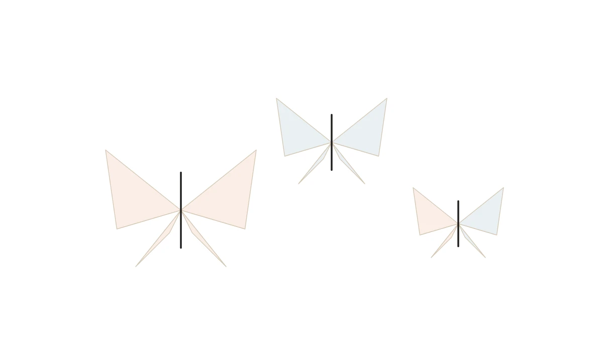Three origami butterflies in orange and blue tones mounted on a light wall
