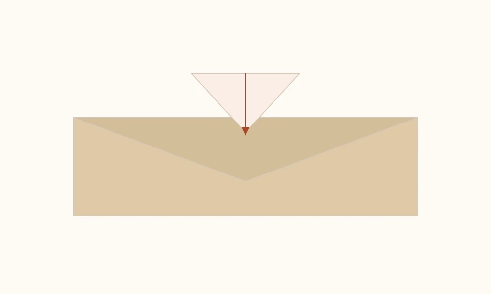 Tip of an envelope flap being tucked under the crossed layers