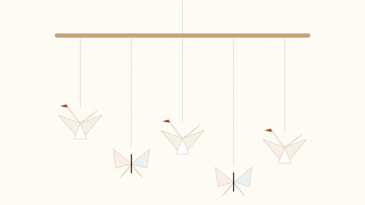 Origami mobile with cranes and butterflies hanging on nylon threads from a wooden rod